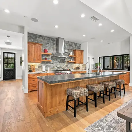 Kitchen island with woven stools and stainless appliances