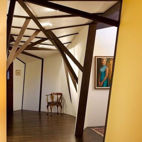 Branching timber columns framing a hallway corner at Canopy House, Carmel-by-the-Sea