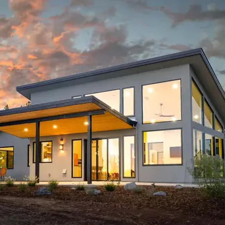 Shed-roof custom home lit at sunset with a cedar-clad overhang in Auburn Lake Trails, CA