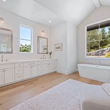 Primary bath with a long double vanity and soaking tub under the window in Meadow Vista, CA