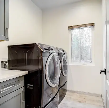 Laundry room with side-by-side machines and a window over the counter in The Motherlode