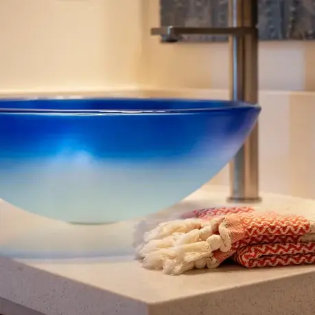 Blue glass vessel sink on a quartz vanity in an Auburn Lake Trails custom home