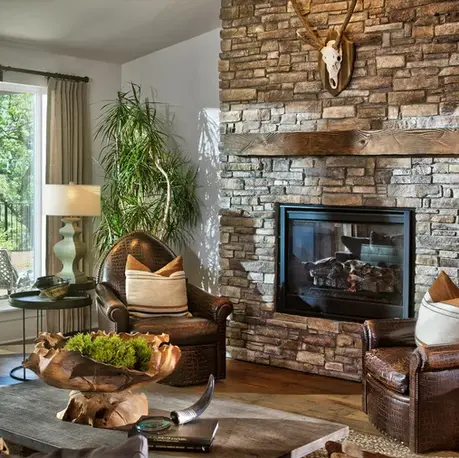 Living room with a floor-to-ceiling stone fireplace and timber mantel in The Alpine