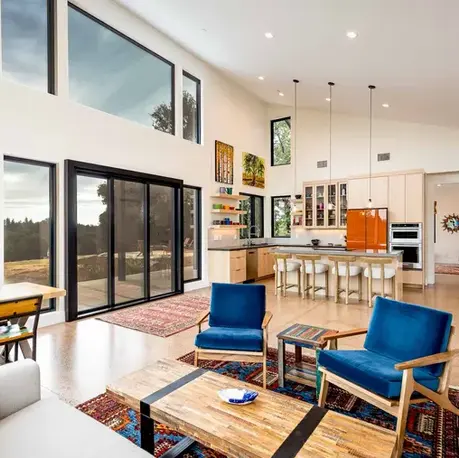 Great room with clerestory glazing and a kitchen island beyond in an Auburn Lake Trails custom home