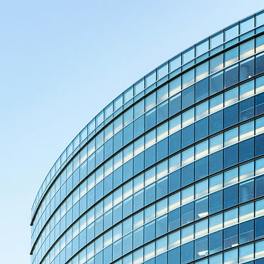 Curved glass office tower against a clear sky