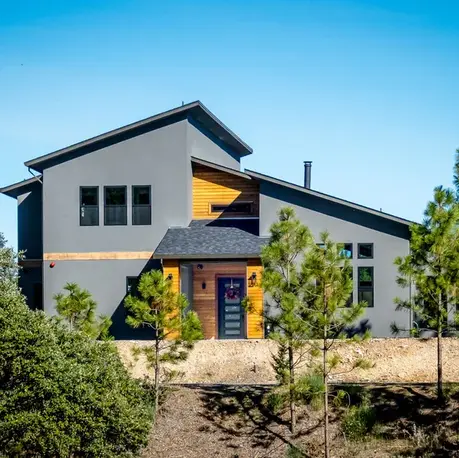Modern mountain cabin with shed roof and cedar entry among the pines in Colfax, CA