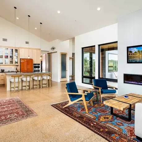 Open kitchen and living room with a linear fireplace and maple cabinetry in Auburn Lake Trails