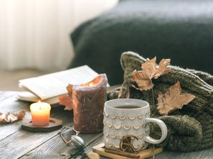 Cozy self-care setup with tea and candles for holiday stress relief and relaxation.