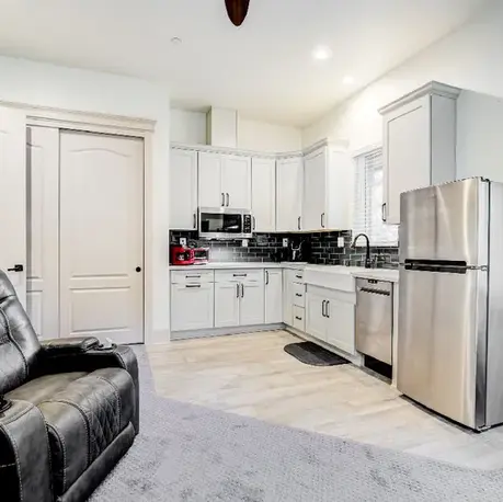 Guest suite kitchen with white cabinetry and full-size appliances in The Motherlode