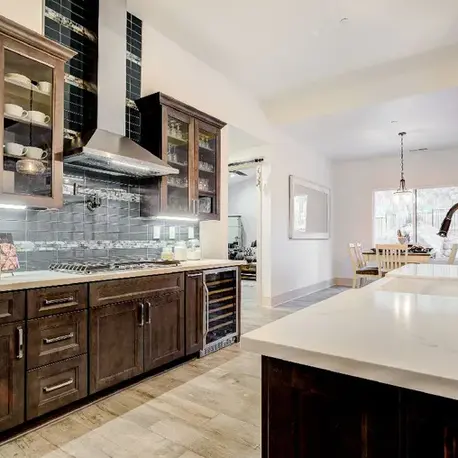 Range wall with a stainless hood and glass-front upper cabinets in The Motherlode