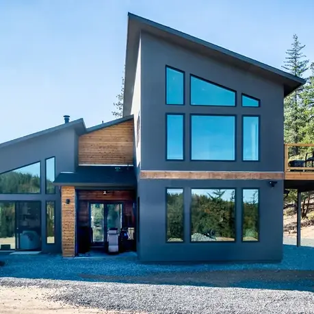 Rear elevation of a Colfax custom home with a two-story window wall and elevated deck