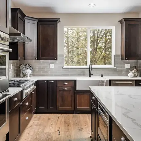 Kitchen range wall with a farmhouse sink and marble counters in The Alpine, Winchester Country Club