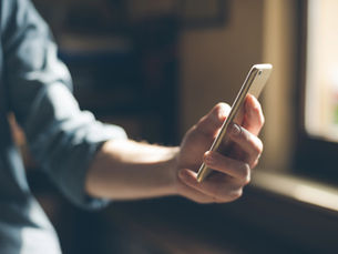 Person holding a smartphone to check their business's AI search visibility