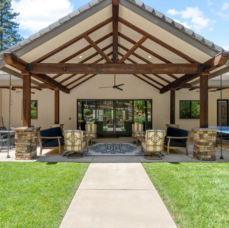 Rear elevation with a timber-framed patio and lawn path at The Ridge