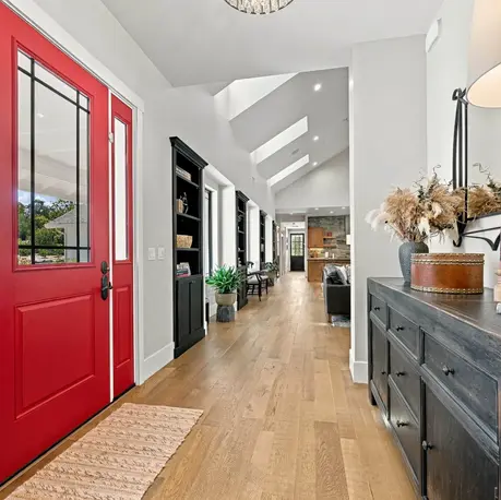 Foyer with red double entry doors and a view into the great room