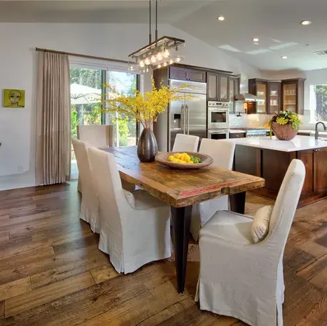 Dining area with a live-edge table open to the kitchen in The Alpine, Winchester Country Club