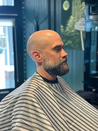Bald client with shaped beard and razor line up at Barbery Coast Barber Shop