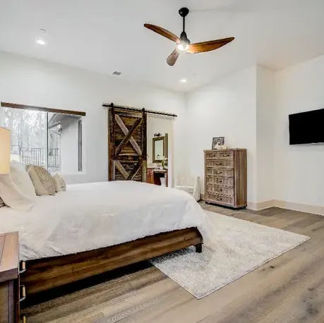 Primary bedroom with a vaulted ceiling and barn door to the bath in The Motherlode