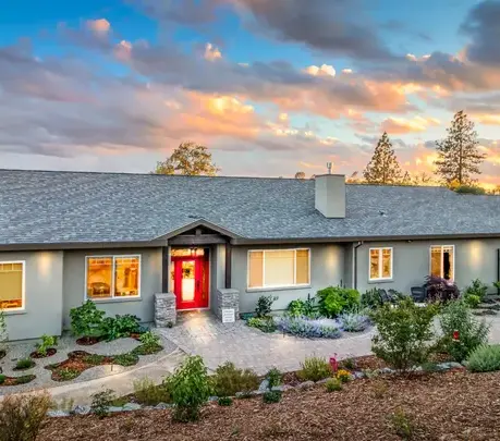 Single-story semi-custom home at sunset with a red front door in Auburn, CA