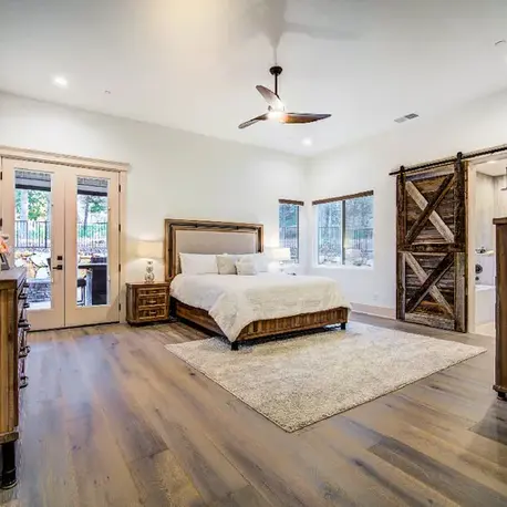 Primary bedroom with a sliding barn door and patio access in The Motherlode