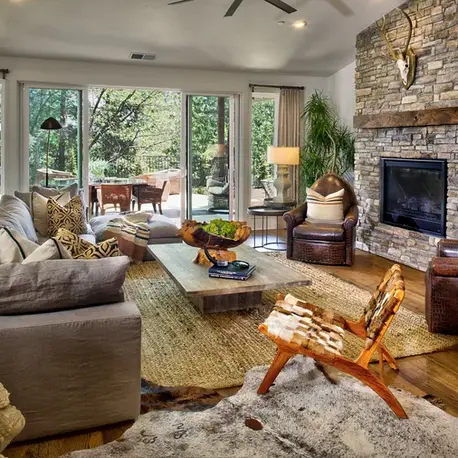 Great room with a stacked-stone fireplace and sliding doors to the patio in The Alpine