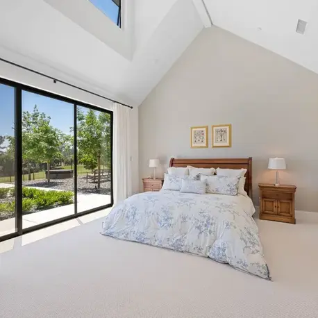 Primary bedroom with a vaulted ceiling and window wall to the lawn in Meadow Vista, CA