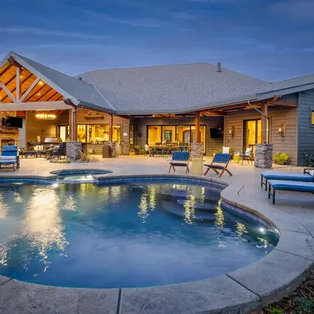 Pool and spa with a timber-frame pavilion lit at dusk at the Christian Valley estate