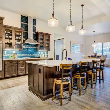 Kitchen with dark cabinetry, blue glass backsplash and wall ovens in The Motherlode