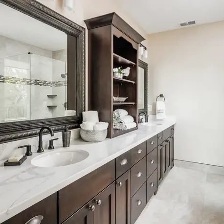 Primary bathroom with a marble double vanity and glass shower in The Alpine