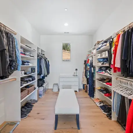 Walk-in closet with built-in shelving and a center bench in Meadow Vista, CA