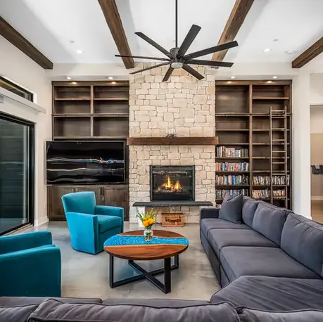 Living room with a stone fireplace and floor-to-ceiling bookshelves in Somerset, CA