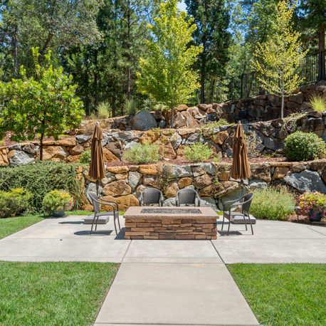 Gas fire pit and patio seating beside the boulder retaining wall at The Ridge
