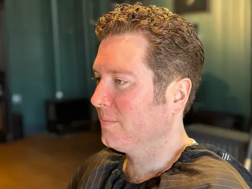 Men's short curly haircut with tapered sides at Barbery Coast Barber Shop in North Beach San Francisco