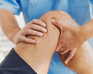 Physiotherapist doing healing treatment on patient leg. Therapist wearing blue uniform. Os