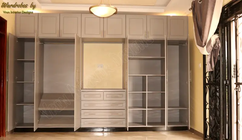 Hinged wardrobe with Tv section in the middle designed by vron interior designs.