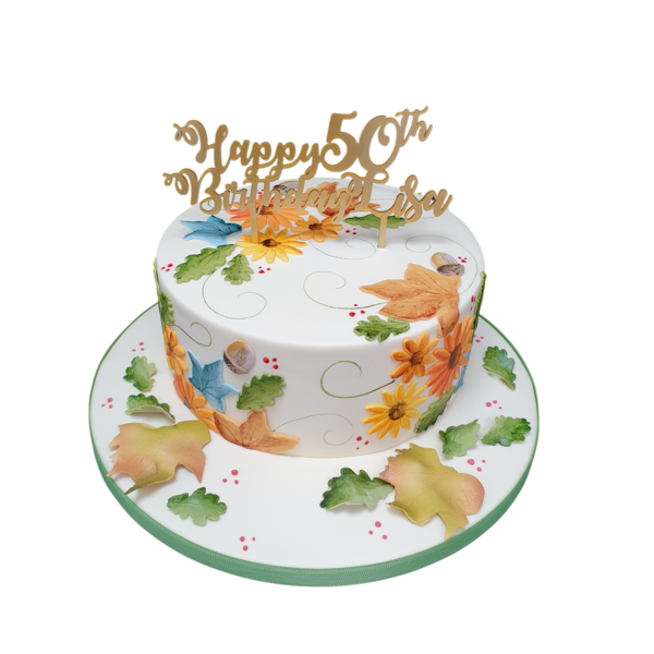 A stunning autumn-themed cake decorated with colorful fondant leaves on top of a smooth buttercream frosting. Perfect for fall celebrations and parties.