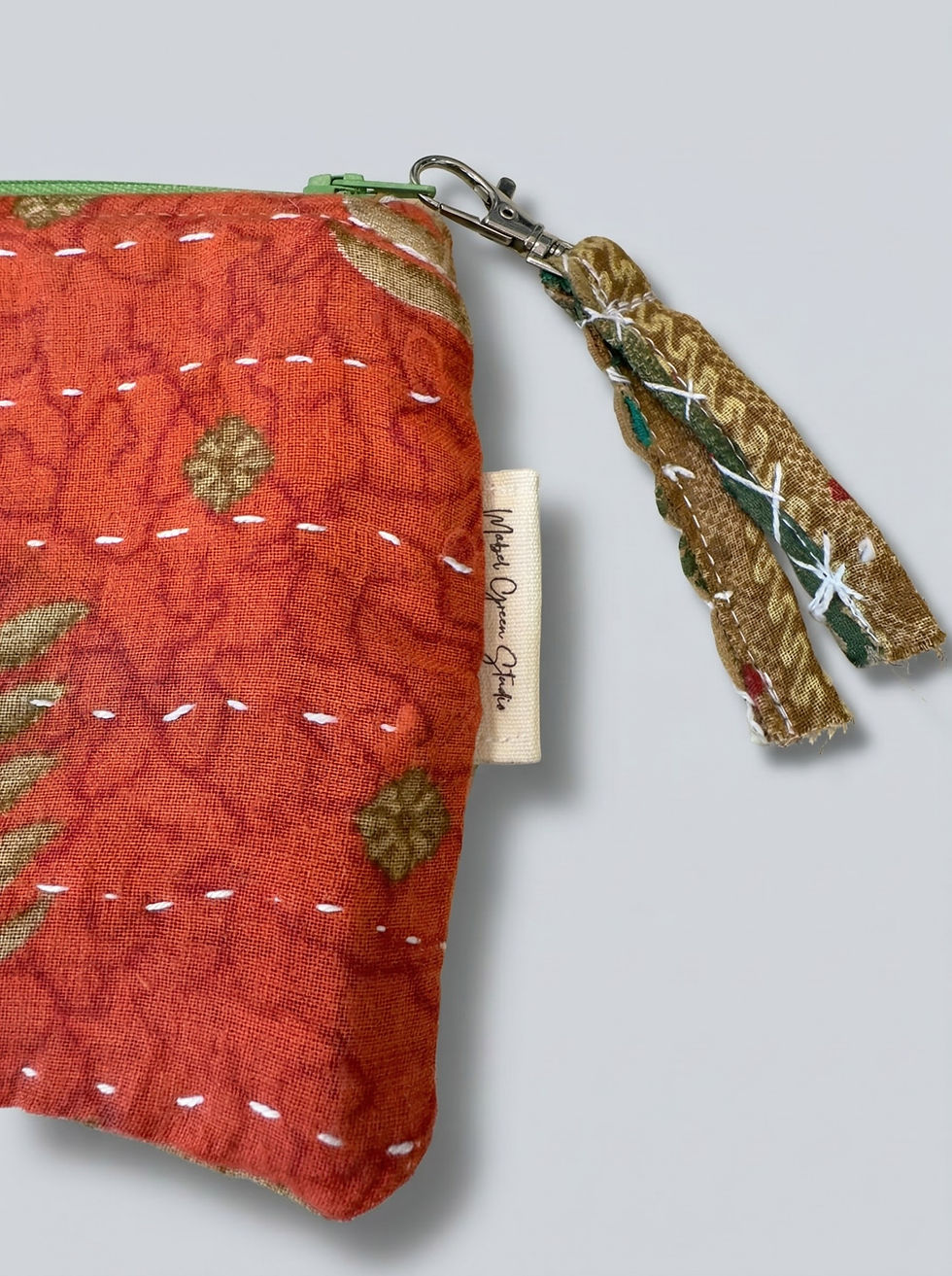 Red fabric pouch, gold pattern, white stitching, decorative zipper