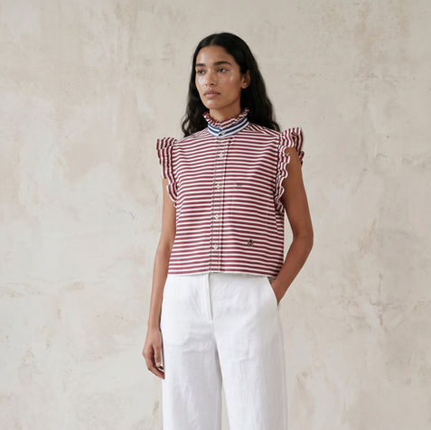 Model wears a reworked Tommy Hilfiger men's shirt which is striped red, white and blue.