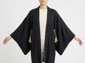 Model wearing a mid-century black silk Japanese haori jacket over a modern cream outfit to demonstrate contemporary styling.