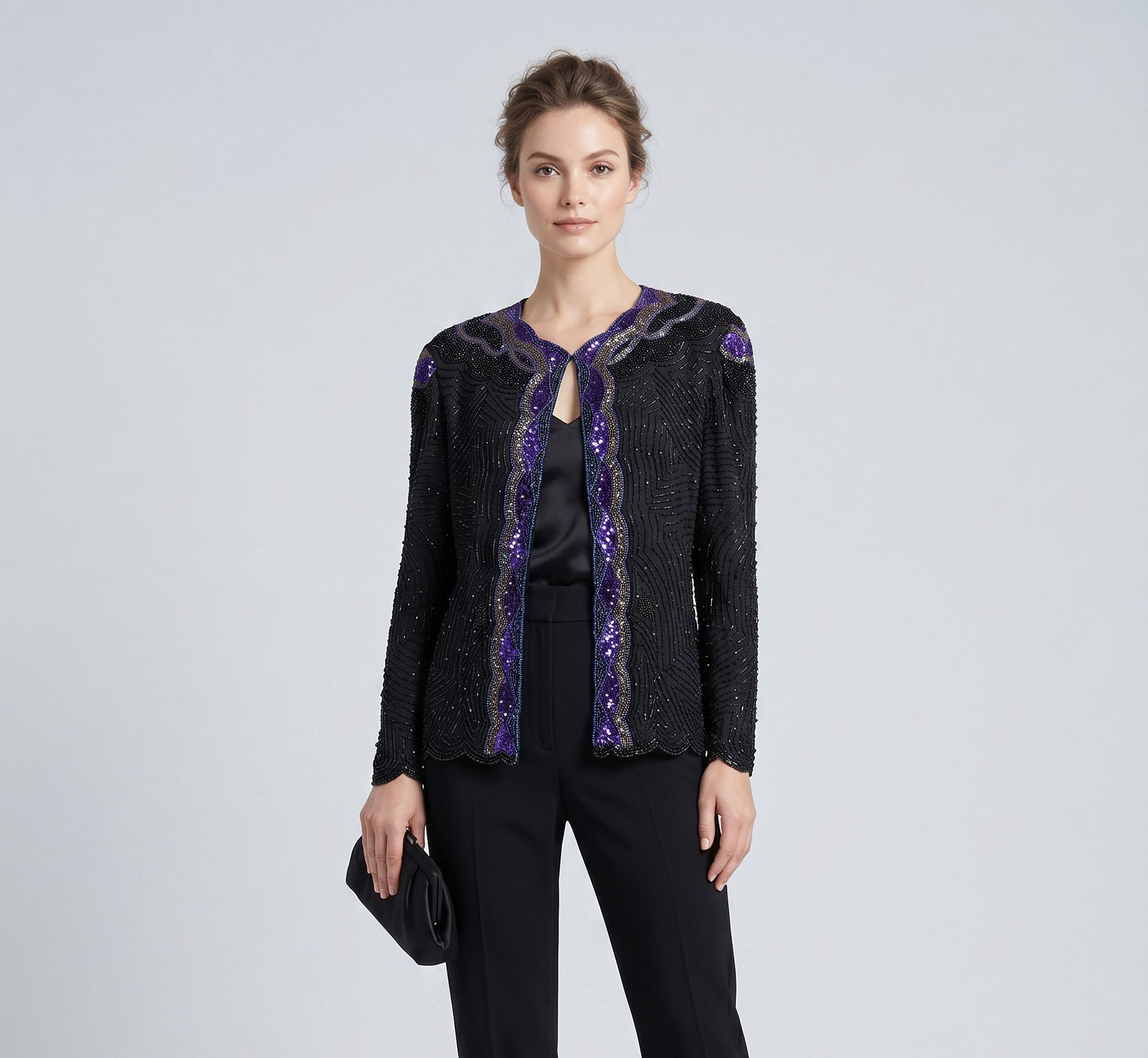 Elegant black beaded evening jacket with purple accents worn over black trousers, styled with heels and a clutch.
