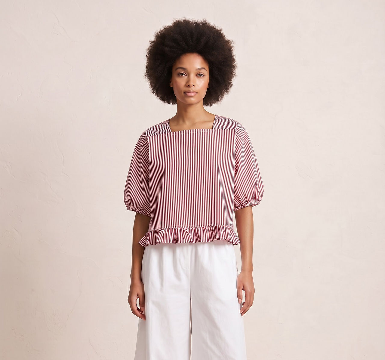 Reimagined Romance: Woman in pink ruffle top and white pants.