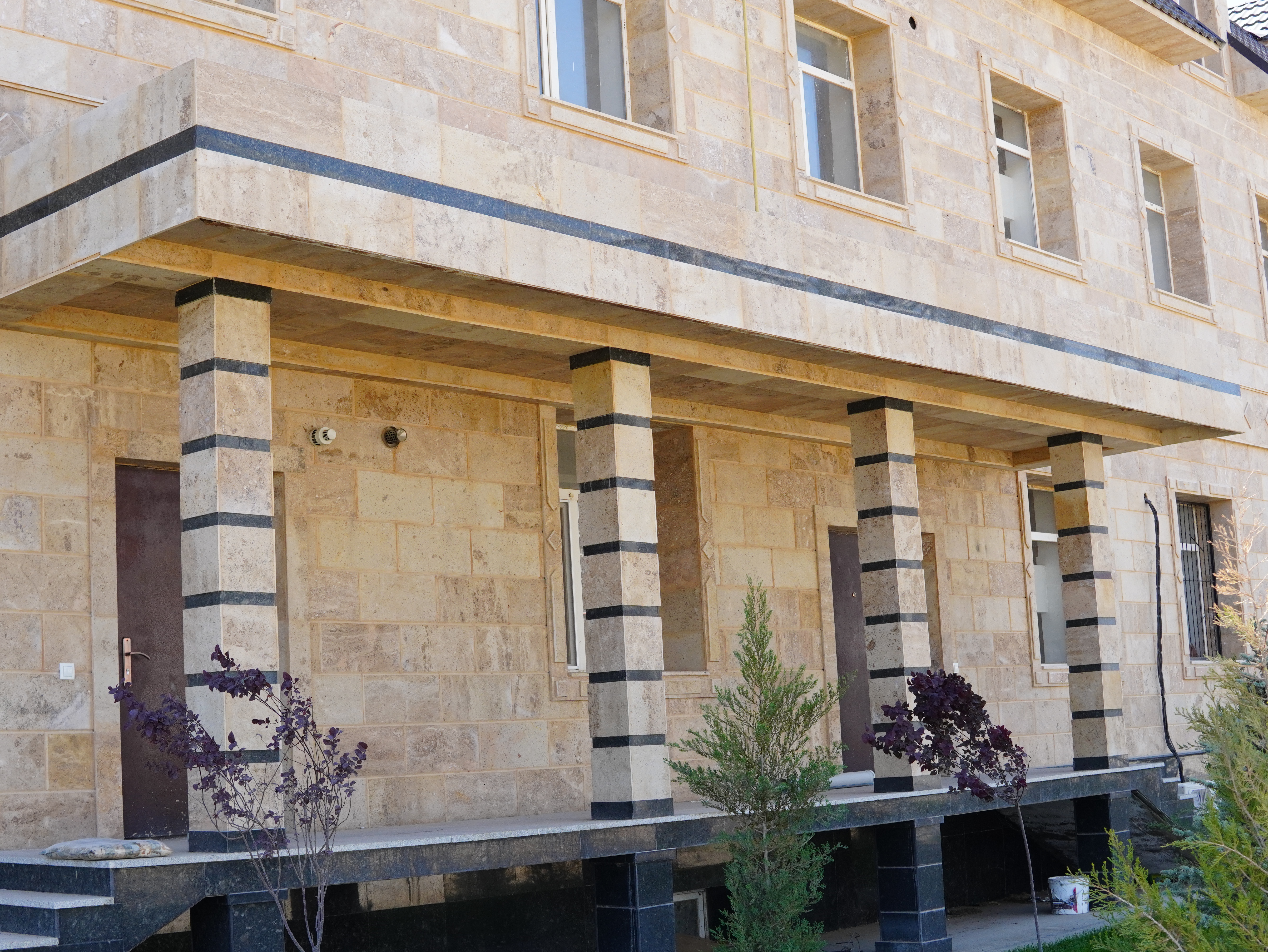 The building's facade is clad in beige travertine 2