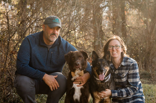 Pat and Morgan outside with a brown dog and a German shepherd