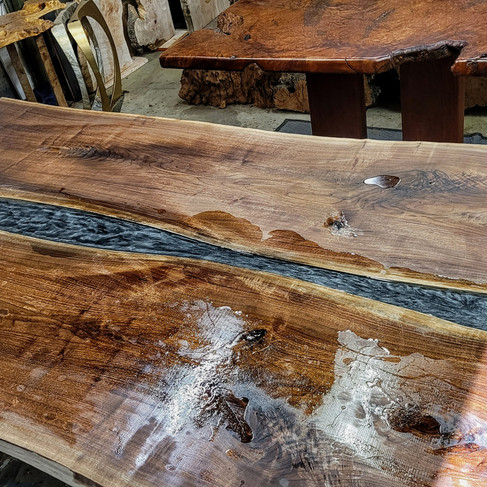 black and silver resin pour in walnut live edge river table