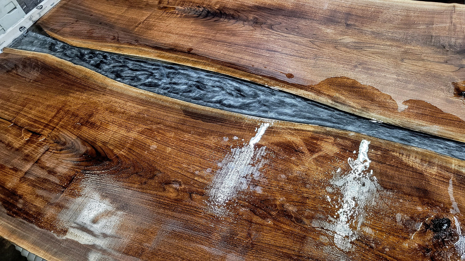 black and silver resin pour in walnut live edge river table