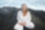 Older woman in lotus pose by the sea