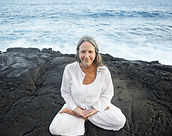 Femme âgée de lotus pose par la mer