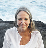 Older woman in lotus pose by the sea