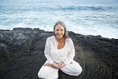 Older woman in lotus pose by the sea