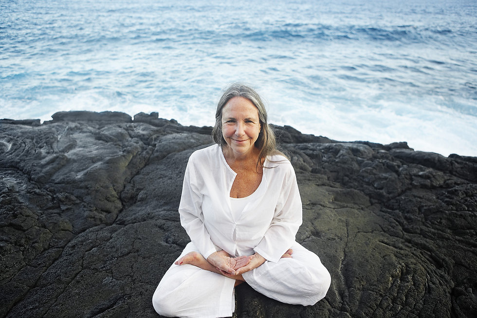 Older woman in lotus pose by the sea